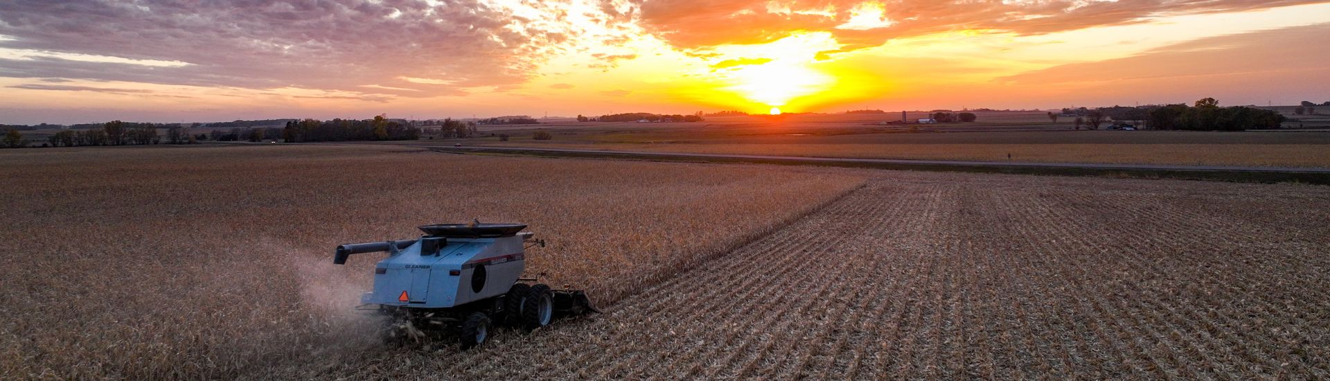 Combine in a field at sunset.